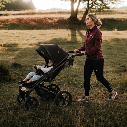 maman promène bebe avec la poussette tout terrain de kaalino