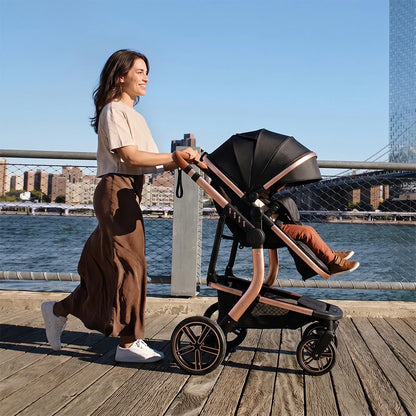 poussette 3 en 1 au bord de l'eau avec maman qui promene bebe